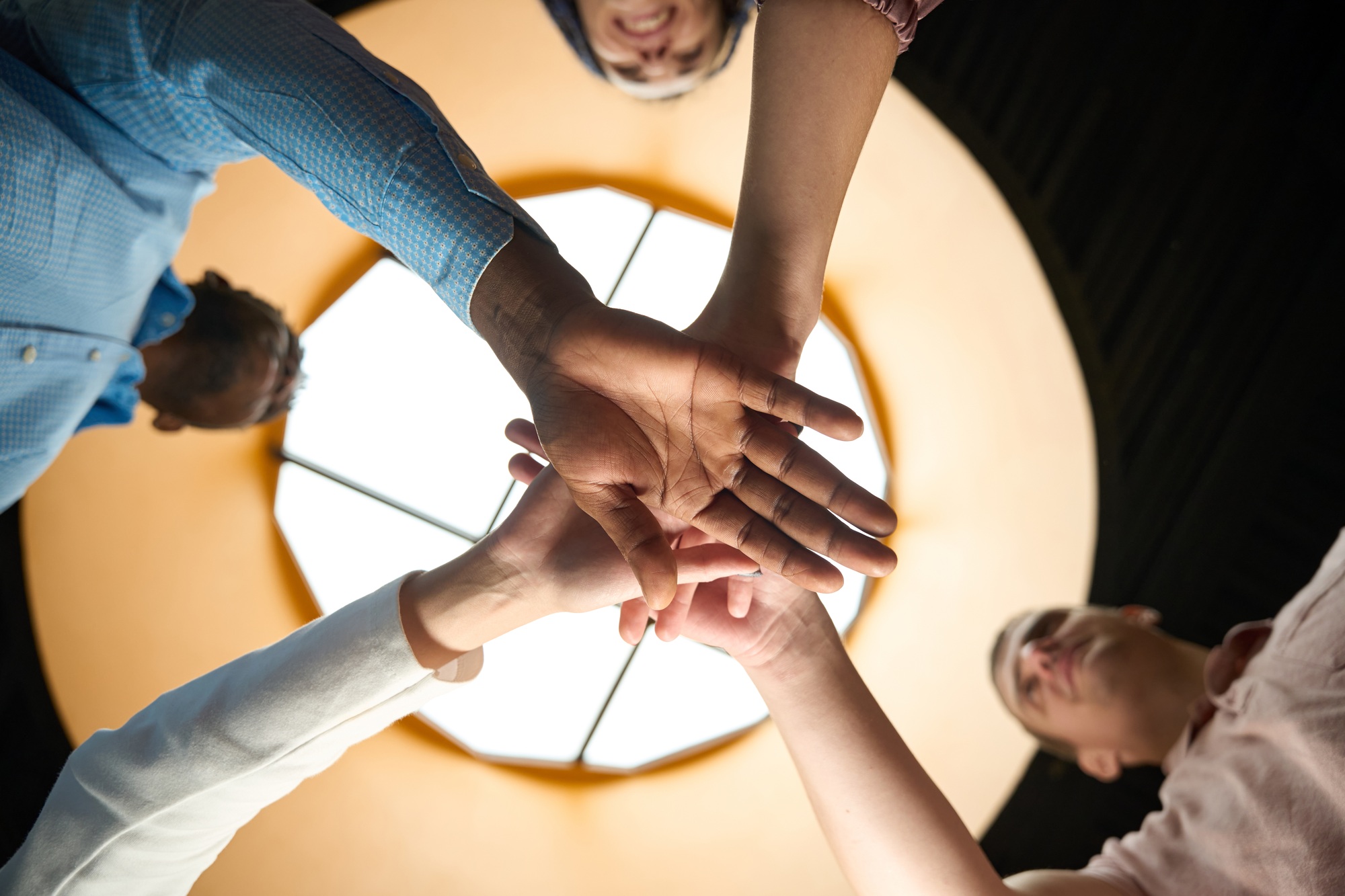 Dedicated team putting hands together as symbol of friendly team
